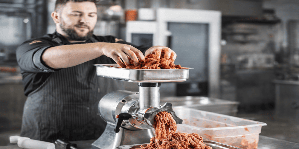 commercial meat grinder machine used in real food processing environment